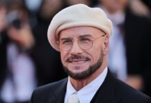 Travolta tips beret-and-glasses homage after Cannes buzz