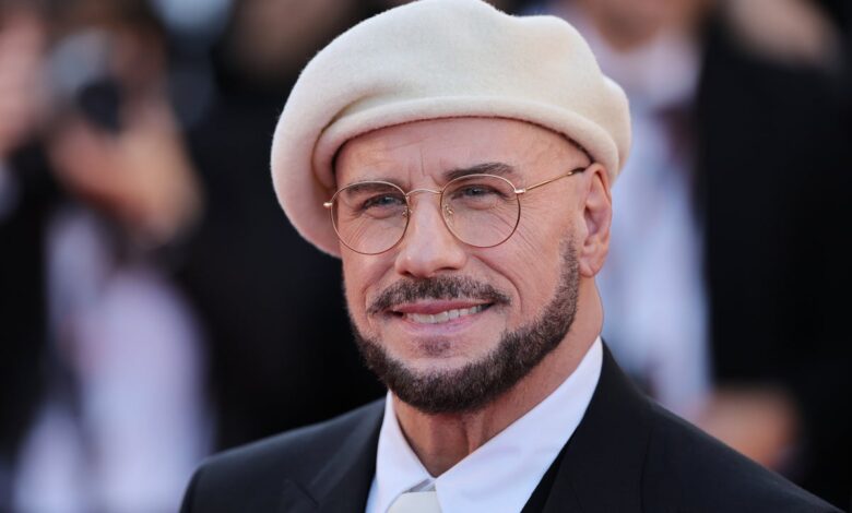 Travolta tips beret-and-glasses homage after Cannes buzz